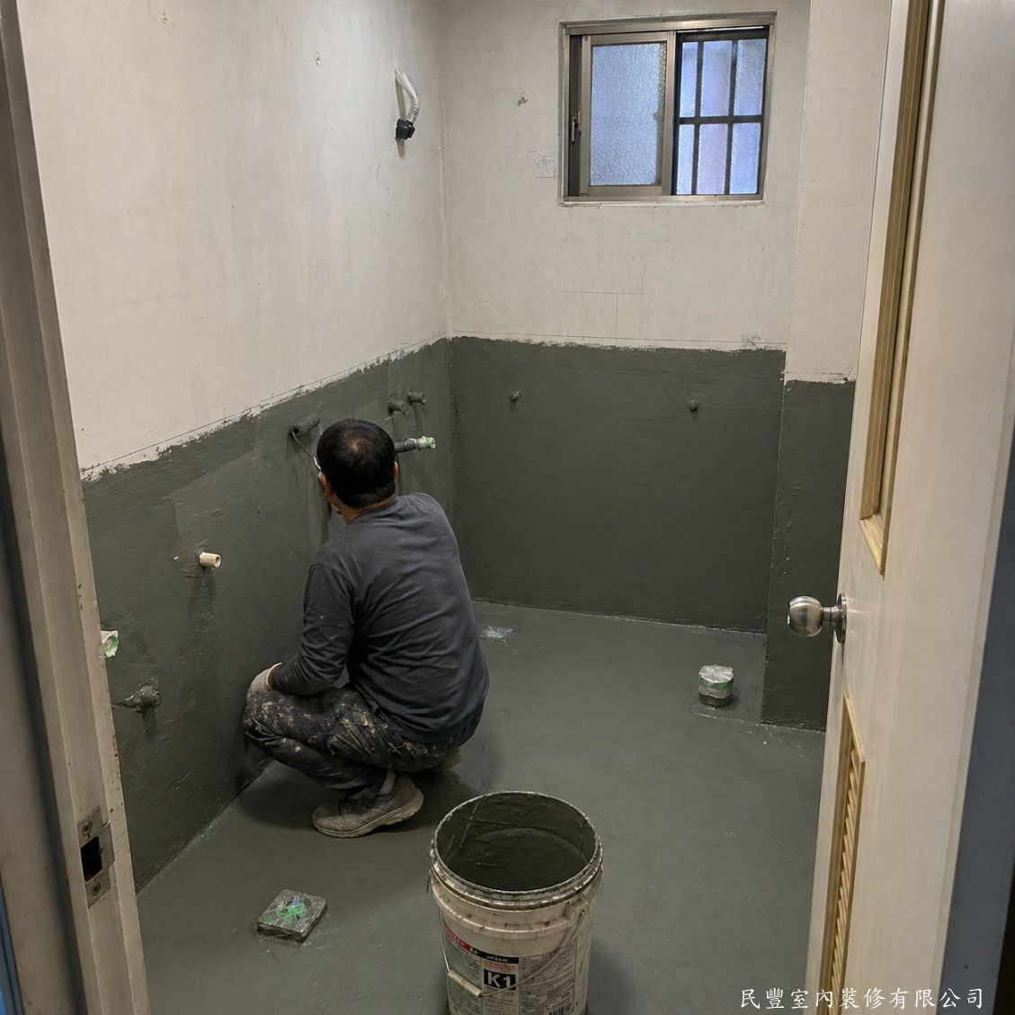 民豐室內裝修-磁磚拆除重貼加玻璃淋浴拉門-拆除完成後，師傅塗佈專業防水塗料，地面與牆面下半部全面覆蓋，形成完整防水層，有效杜絕日後漏水問題，保障鄰居及結構安全
