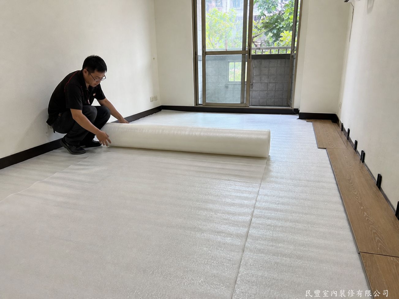 民豐室內裝修-超耐磨木地板浮鋪翻新-清潔完成後，師傅鋪設防潮緩衝墊，有效隔離地面濕氣並緩衝踩踏噪音，同時可看到右側木地板已開始拼接，施工效率高